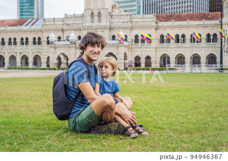 Dad and son on background of Merdeka square and Sultan Abdul Samad Building. Traveling with children concept Dad and son on background of Merdeka square and Sultan Abdul Samad Building. Traveling with children concept 94946367