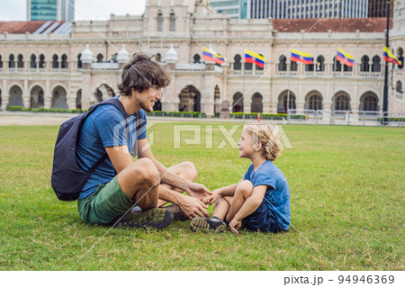 Dad and son on background of Merdeka square and Sultan Abdul Samad Building. Traveling with children concept 94946369