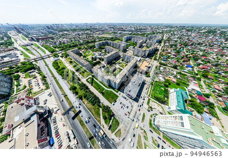 Aerial city view with crossroads and roads, houses, buildings, parks and parking lots. Sunny summer panoramic image 94946563