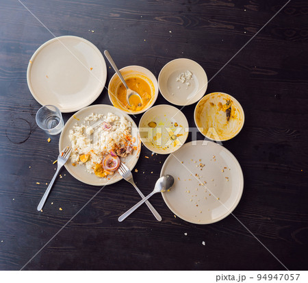 The remains of food in plates, crumbs on the table after lunch or dinner 94947057