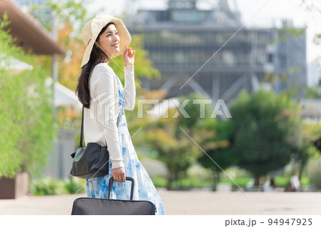 スーツケースを引いて名古屋観光をする若い女性 94947925