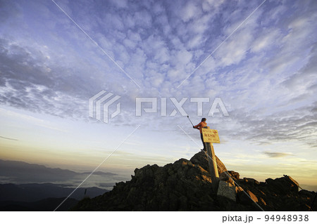 仙丈ケ岳山頂からの展望を撮影する登山者 94948938