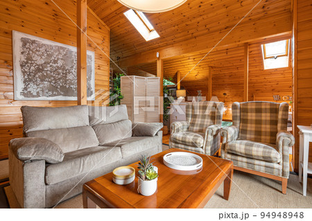 Cozy living room on the second floor of wooden house in a village. Comfortable furniture for evenings with family. 94948948