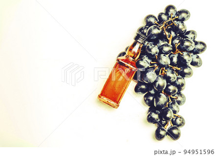 Good old brandy cognac and black ripe grapes and on white 94951596