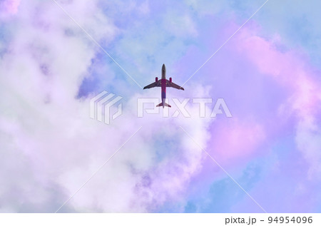 Red passenger plane in blue sky with pink clouds Red passenger plane in blue sky with pink clouds 94954096