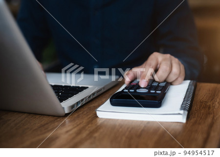 Hand busineaaman doing finances and calculate on desk about cost at office. 94954517