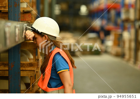 Warehouse workers wearing safety hardhat working on retail warehouse full of packed boxes and goods Warehouse workers wearing safety hardhat working on retail warehouse full of packed boxes and goods 94955651