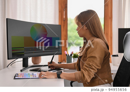 Young creative woman using graphic tablet and professional computer working for design project at home office Young creative woman using graphic tablet and professional computer working for design project at home office 94955656