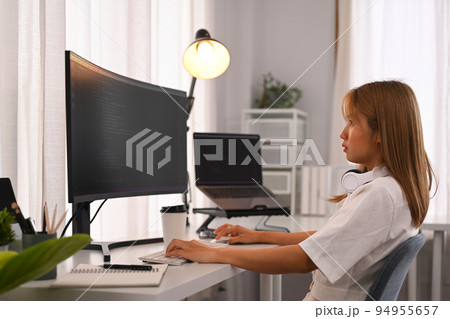 Young female programmer working with coded data on desktop computer in bright modern office Young female programmer working with coded data on desktop computer in bright modern office 94955657