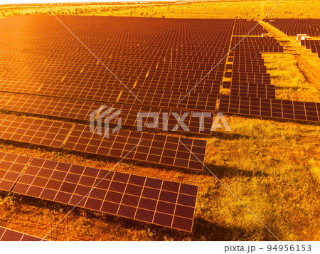 Aerial top view of a solar panels power plant. Photovoltaic solar panels at sunrise and sunset in countryside from above. Modern technology, climate care, earth saving, renewable energy concept. 94956153
