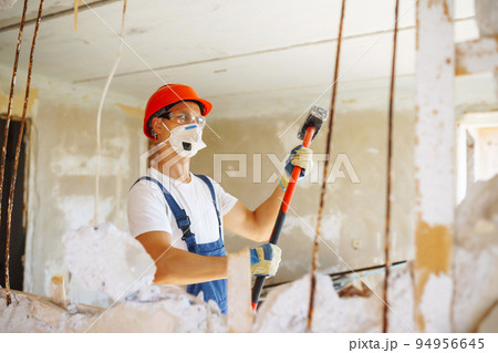 Young male builder in hard hat holding tools. Apartment repair and renovation concept. 94956645