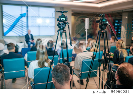 Cameras shooting business conference in modern auditorium 94960082