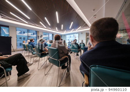 Businesspeople watching presentation in evening Businesspeople watching presentation in evening 94960110