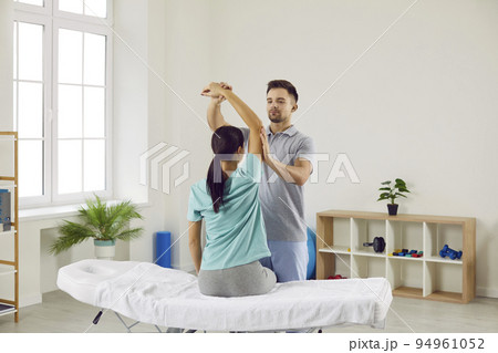 Chiropractor, physiotherapist or osteopath at rehabilitation clinic helping his patient 94961052
