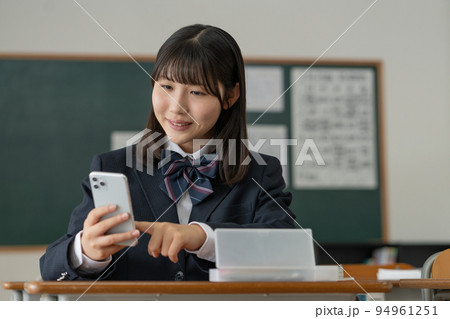 学校の教室でスマホを操作する女子高生 94961251
