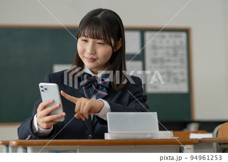 学校の教室でスマホを操作する女子高生 94961253
