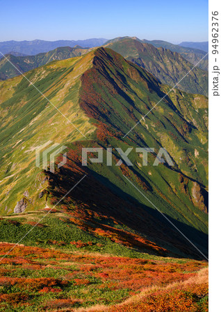 秋の谷川岳・紅葉する主脈稜線と快晴の空 94962376