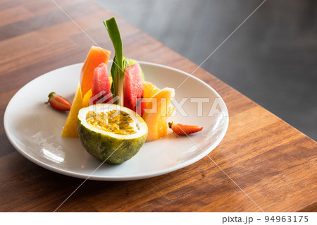 Fruit plate stands on a wooden table, close up 94963175