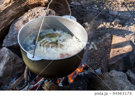 Boiling cauldron hangs over an open fire, Boiling cauldron hangs over an open fire, 94963179
