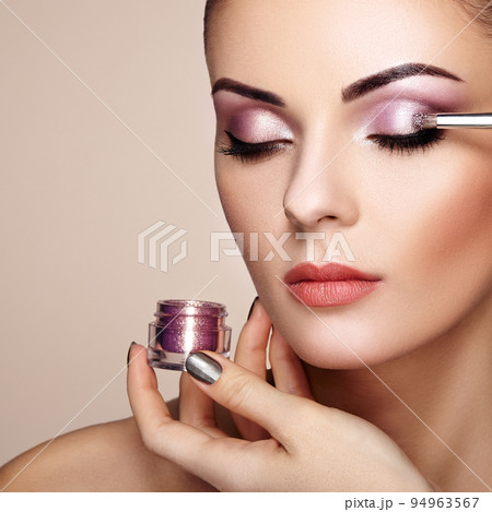 Makeup artist applies eye shadow 94963567