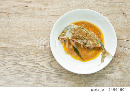spicy boiled mackerel topping chop lemon grass in red curry sauce on plate 94964604