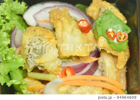 deep fried slice snake skin gourami spicy and sour Thai salad on bowl 94964609