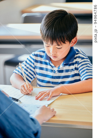 ノートに書き取りをする小学生の男の子 94964786