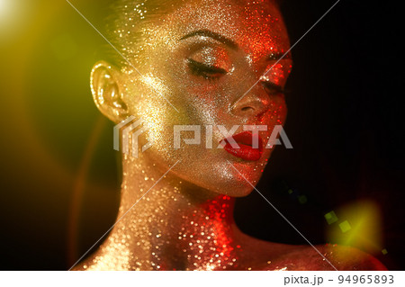 Portrait of beautiful woman with sparkles on her face 94965893