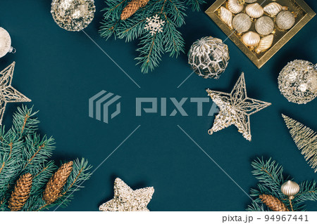 Merry Christmas and Happy New Year rich golden and crystal baubles festive ornaments. stars glitter and Christmas tree branches with cones on teal green. Party decor banner. Top view 94967441