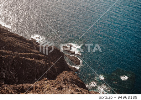 View from above of a volcanic cliff over the sea View from above of a volcanic cliff over the sea 94968189