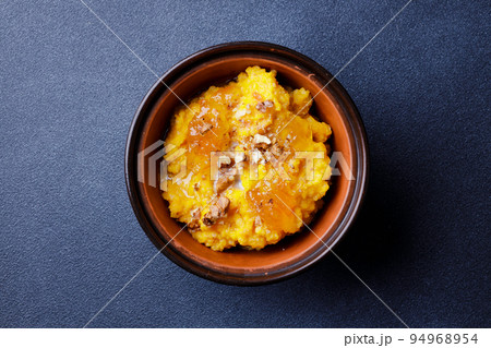 Sweet pumpkin porridge in clay bowl with jam and nuts Sweet pumpkin porridge in clay bowl with jam and nuts 94968954