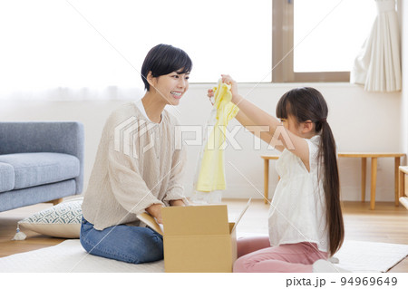 ダンボールを開ける親子 94969649