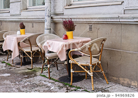 Empty cafe tables on city street waiting for visitors. Autumn blues. Autumn flowers. Heather 94969826