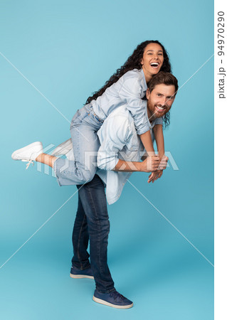 Laughing young european male holding on back middle eastern woman, have fun together, enjoy free time 94970290