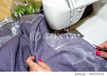 Woman sewing a curtain at home 94970533