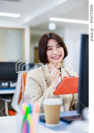 オフィスでタブレットを使って仕事をする女性 オフィスでタブレットを使って仕事をする女性 94970886