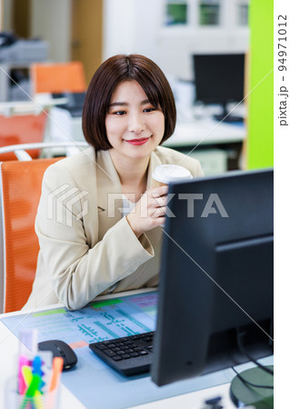 オフィスでコーヒーを飲んで休憩する女性 94971012