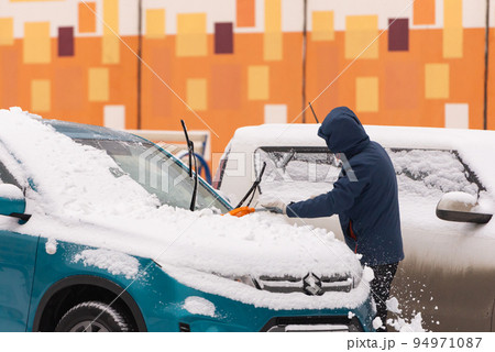 Cleaning the car after a snowfall 94971087