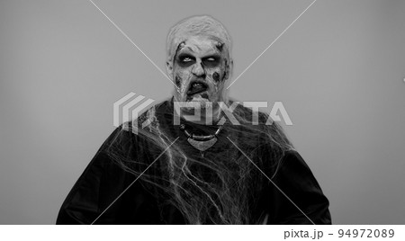 Sinister man scary Halloween zombie making playful silly facial expressions grimacing fooling around Sinister man scary Halloween zombie making playful silly facial expressions grimacing fooling around 94972089