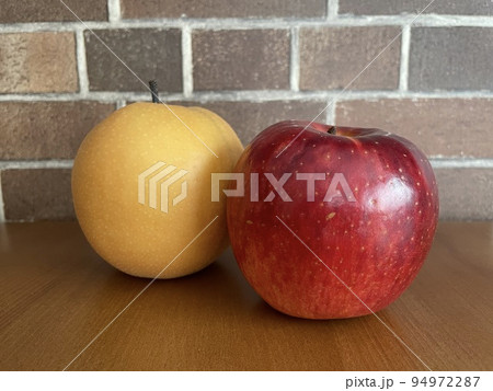 少しずらして置かれた美味しそうな林檎と梨 少しずらして置かれた美味しそうな林檎と梨 94972287