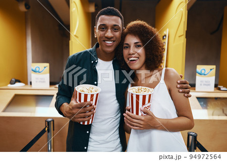 A man and a woman came to the cinema. People in 3D glasses and with popcorn are ready for a movie. 94972564