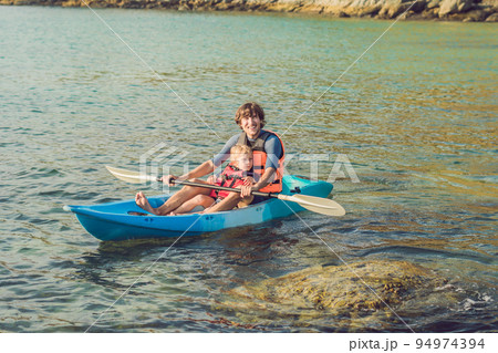 Father and son kayaking at tropical ocean. 94974394