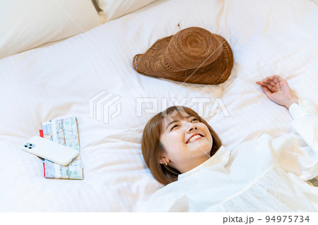 ホテルのベッドでゆったりする女性  94975734