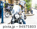 大型アメリカンバイクに乗って横浜元町ショッピングストリートに来た女性ライダー　後方確認 94975803
