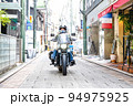 大型アメリカンバイクに乗って横浜元町ショッピングストリートに買い物に来た女性ライダー 94975925