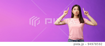 Sad disappointed sulking asian girl with short dark haircut, look pointing up upset, feel jealous, regret, missing good opportunity, staring unhappy top advertisement, stand purple background Sad disappointed sulking asian girl with short dark haircut, look pointing up upset, feel jealous, regret, missing good opportunity, staring unhappy top advertisement, stand purple background 94978592