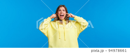 Turn off this awful music. Annoyed and bothered displeased angry blond girl, screaming at ceiling and look up as telling neighbours stop being too loud, shut ears from loud noise 94978661