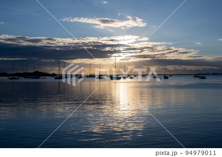 Sailboats in Dinner Key anchorage reflected in calm water of Biscayne Bay. 94979011