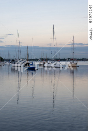 Sailboats in Dinner Key anchorage reflected in calm water of Biscayne Bay. 94979144