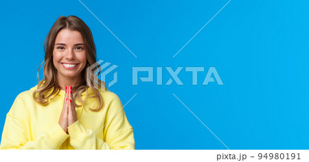 Close-up portrait of cute cheerful smiling blond girl with short hair, clasp hands together in namaste or pray gesture, thanking for help, bowing namaste gesture, standing grateful blue background Close-up portrait of cute cheerful smiling blond girl with short hair, clasp hands together in namaste or pray gesture, thanking for help, bowing namaste gesture, standing grateful blue background 94980191
